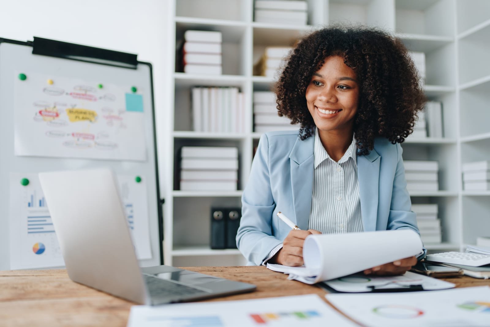 54071748_beautiful-young-african-american-businesswoman-using-laptop-computer-and-paperworks-with-planning-working-on-financial-document-tax-exchange-accounting-and-financial-advisor