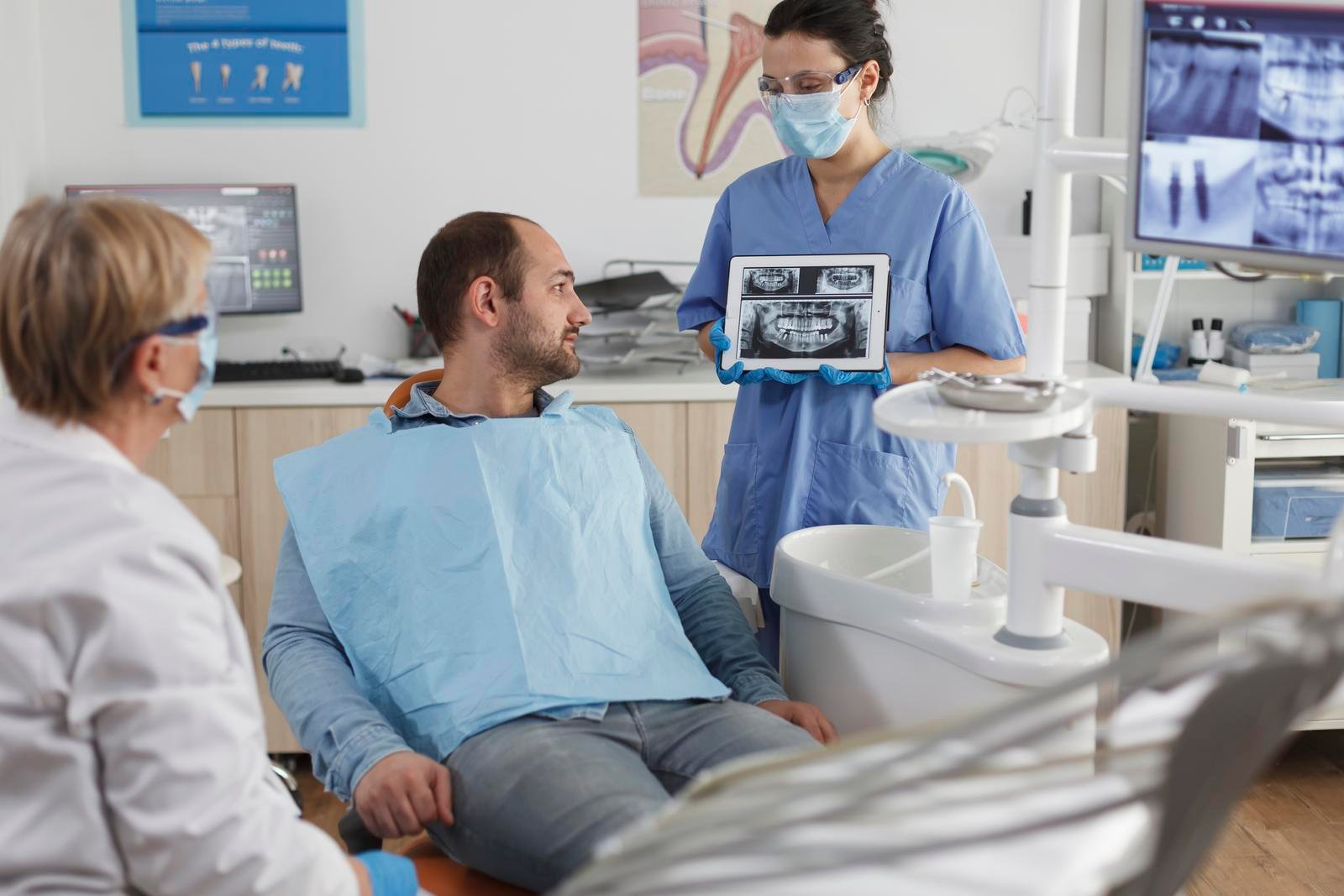 Dentist assistant with face mask holding tabet computer