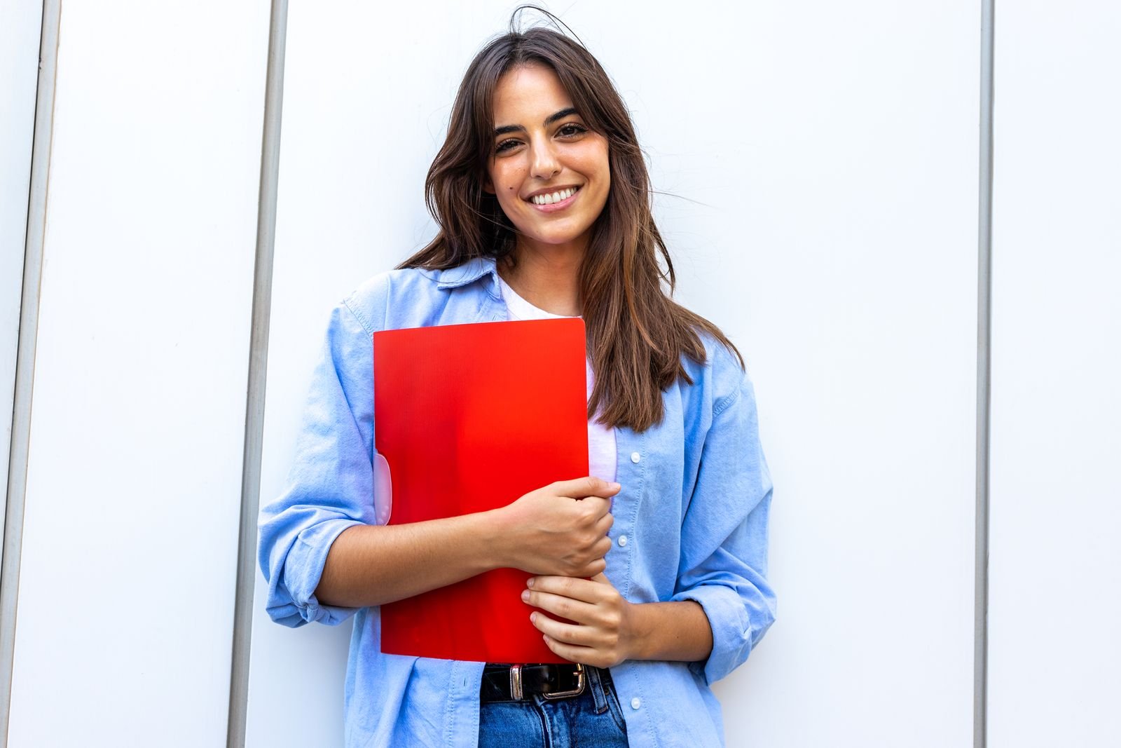49643106_happy-smiling-female-college-student-looking-at-camera-holding-red-folder