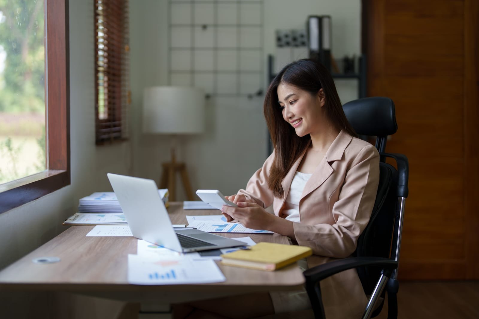 51325896_businesswoman-or-accountant-working-on-calculator-and-laptop-computer-to-calculate-business-data-during-using-accountancy-document-at-office